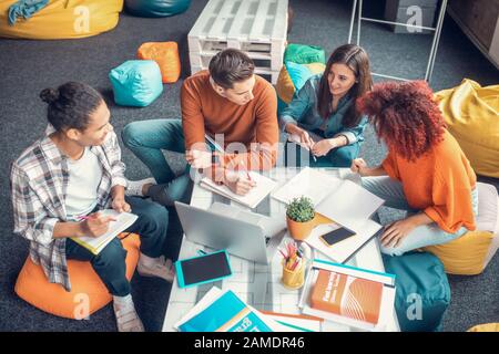 Les étudiants ayant une discussion de groupe pendant la préparation du projet de groupe Banque D'Images