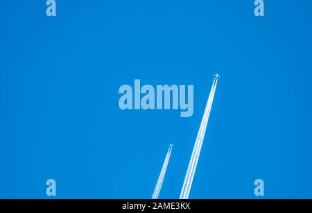 Deux avions avec des pistes de condensation blanches. Avion jet sur ciel bleu clair avec piste de vapeur. Voyage par avion concept. Pistes de gaz d'échappement de Banque D'Images