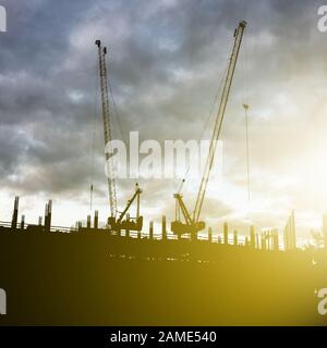 Construction d'un gratte-ciel, immeuble résidentiel ou un immeuble de bureaux. Silhouettes de grues industrielles. Extérieur urbaine et commerciale. Le p Banque D'Images