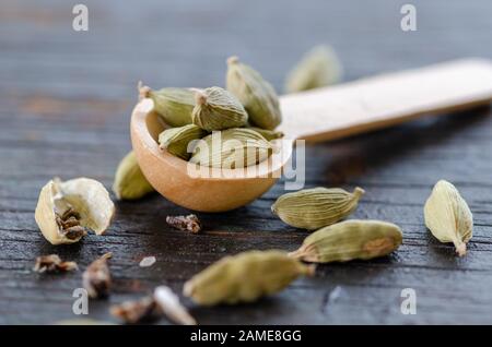 Gousses de cardamome vert séché sur table en bois, ferme et vue de dessus. Banque D'Images