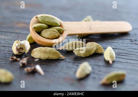 Gousses de cardamome vert séché sur table en bois, ferme et vue de dessus. Banque D'Images