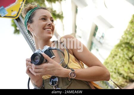 Jeune femme élégante avec vintage appareil photo en milieu urbain Banque D'Images