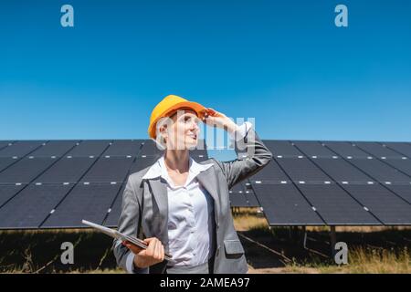 Femme d'affaires ou de l'investisseur l'inspection de sa ferme solaire Banque D'Images
