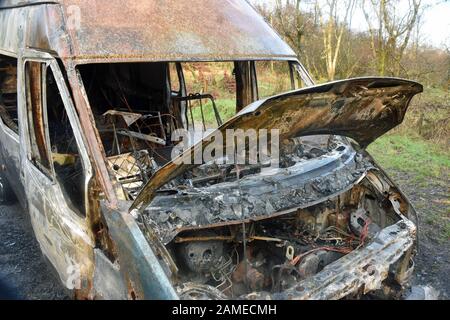 Gros plan sur une fourgonnette brûlée montrant des dommages extrêmes au feu. Prise à l'avant avec capot/capot moteur levé montrant les détails du moteur. Banque D'Images