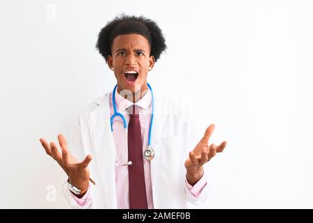 Jeune homme de médecin africain américain portant un sthetoscope sur fond blanc isolé folle et folle criant et hurlant avec l'expression agressive et Banque D'Images