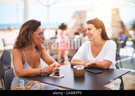 Belle Mère et fille assis à une terrasse de restaurant parlant et souriant Banque D'Images
