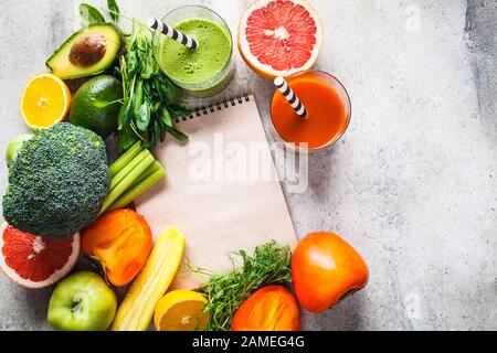 Smoothie detox vert et orange dans le verre. Ingrédients pour le fond de smoothie detox. Concept de nourriture saine. Banque D'Images