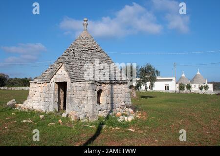 Groupe de Trulli magnifique avec des oliviers, des maisons anciennes et de vieux mur de pierre dans les Pouilles, Italie, Europe Banque D'Images