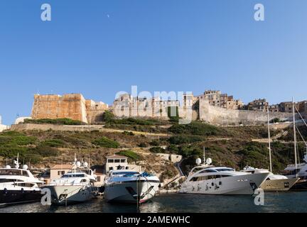 Yachts de luxe ancrés en face de la célèbre citadelle de Bonifacio en Corse en France lors d'une journée d'été ensoleillée. Banque D'Images