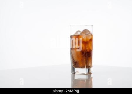 Verre de cola froid rafraîchissant avec glace sur fond blanc avec espace pour le texte. Boisson glacée de boisson fraîche avec caféine Banque D'Images