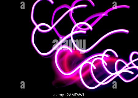 Image abstraite des lumières néons roses ou lilas sur un fond sombre. Banque D'Images