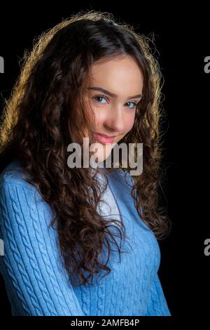 Jeune fille posant pour des photos de studio sur un fond noir, Banque D'Images