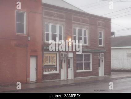 Salon de coiffure à la sortie de la rue principale d'un petit village lors d'une journée d'hiver brumeuse Banque D'Images