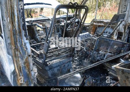 Détail de la fourgonnette endommagée par l'incendie montrant les restes des sièges et du tableau de bord. Incendie extrême. Banque D'Images