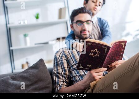 foyer sélectif du père et du fils juifs lisant le tanakh dans l'appartement Banque D'Images