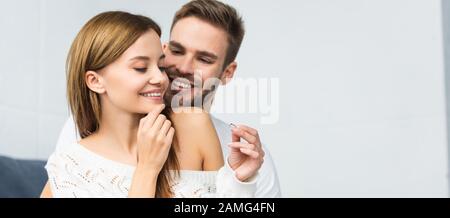 photo panoramique de beau homme faisant la proposition de mariage à la femme souriante et attrayante Banque D'Images
