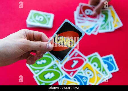 Kiev, UKRAINE - 22 NOVEMBRE 2019: Vue courte de l'homme tenant uno carte de jeu isolée sur le rouge Banque D'Images