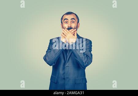 Portrait de l'homme choqué couvrant la bouche avec les mains. Corps isolé, demi-longueur, fond jaune vert clair. Émotions humaines expressions du visage corps lan Banque D'Images