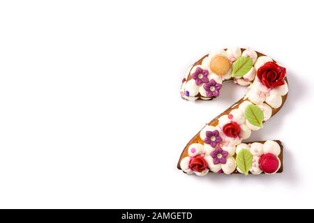 Gâteau numéro deux décoré de fleurs et de macarons isolés sur fond blanc. Espace de copie Banque D'Images