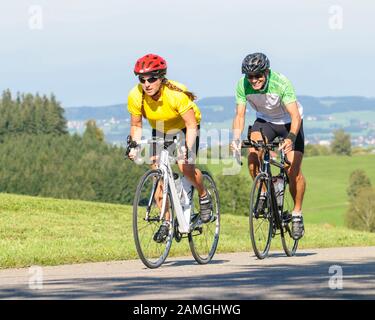 Couple faisant un tour à vélo sur vélo de course à un après-midi ensoleillé de Bavière Allgäu Banque D'Images