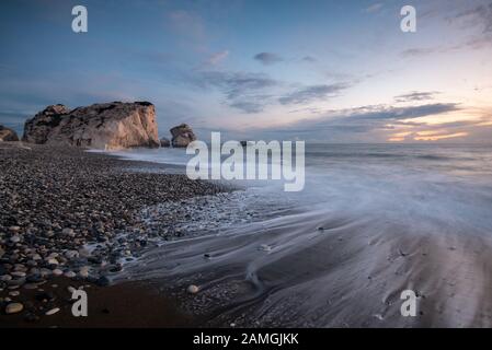 Au cours des vagues de vent marin avec un temps orageux à rocky dans les zones côtières de la Rock d'Aphrodite à Paphos, Chypre. Banque D'Images