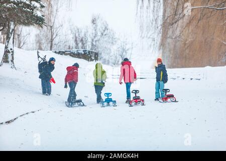 Lviv, Ukraine - 5 janvier 2019: Les enfants garçons amis tirant en traîneau à la colline escarpée Banque D'Images