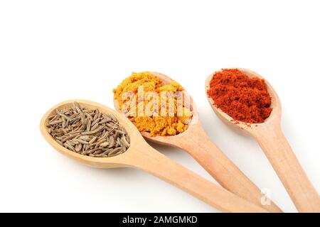 Cuillères à bois avec poivre rouge, caraway et curcuma isolées sur fond blanc Banque D'Images