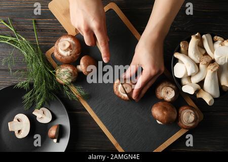Femme coupe le champignon à bord avec des champignons, vue de dessus Banque D'Images