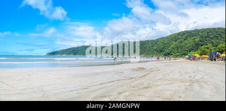 Les gens d'une plage brésilienne une journée ensoleillée. Vue panoramique. Plage avec une mer calme et quelques vagues à Praia do Guaiuba plage - Guaruja SP Brésil. Banque D'Images
