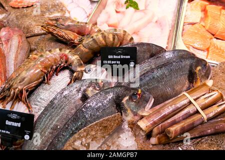 Tête de poisson Dorade doré à vendre dans des présentoirs réfrigérés sur la glace contre E. Ashton en décrochage des poissonniers du marché de Cardiff au Pays de Galles UK KATHY DEWITT Banque D'Images