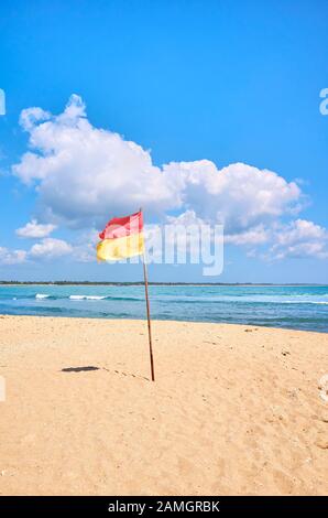 Plage tropicale avec drapeau rouge et jaune, Sri Lanka. Banque D'Images