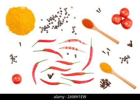 Petits pains d'épices sur fond blanc isolé : curcuma, poudre de piment rouge, gousses de poivre rouge, poivre noir, clous de girofle, tomates Banque D'Images