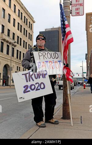 Un partisan de Trump se tient avec des signes indiquant « Fier Patriot » et « Construire le mur de Damn » dans une rue de Tolède, Ohio, États-Unis lors d'un rassemblement politique de Trump. Banque D'Images