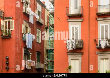 Séchage de vêtements sur des étagères et des cordes dans la rue du centre historique de Naples Banque D'Images