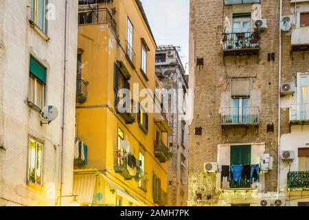 Séchage de vêtements sur des étagères et des cordes dans la rue du centre historique de Naples Banque D'Images