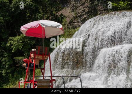 2 août 2019 - Ithaca, NY, États-Unis,: Le stand de sauveteur devant la chute d'eau et la piscine naturelle au parc d'état Robert H. Treman, Finger Lakes Banque D'Images