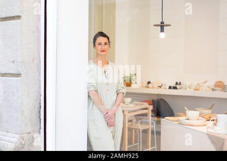 Femme au travail porter dans son atelier à côté de la fenêtre Banque D'Images