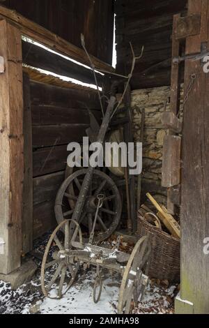 Vieilles roues et portes en bois et charrue pour labourage dans la grange en hiver Banque D'Images