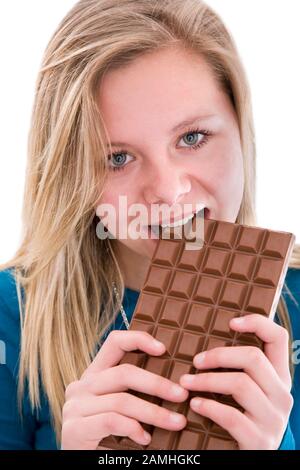 Gros plan d'une jeune fille téengae mangeant un grand bar de chocolat Banque D'Images