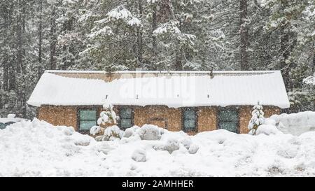 Une maison colorée isolée dans la montagne, dans la Sierra Nevada, Californie, sous une tempête de neige Banque D'Images