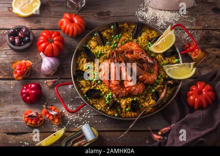 De délicieux fruits de mer paella avec des légumes sur une table, style rustique Banque D'Images