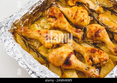 Appétissant Pattes de poulet Cuites avec Des Pommes De Terre et du romarin dans le film. Gros plan. Banque D'Images