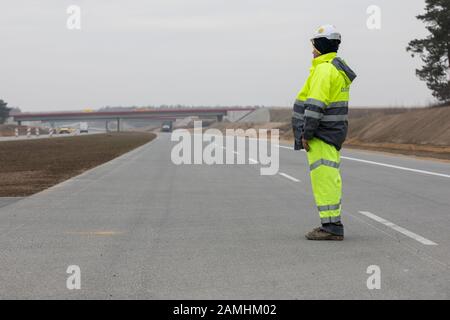 Pologne, SILESIA-Budimex travailleur de la construction dans un équipement de travail jaune. Construction d'une nouvelle section de l'autoroute Ambre (Autostrada Bursztynowa)A1 Banque D'Images