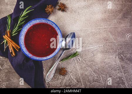 Sauce douce épicée à base de canneberges de la forêt du nord et de pommes au romarin, à la cannelle et aux étoiles anis dans un bol bleu. Vue De Dessus. Lieu Banque D'Images