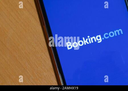 Saint-Pétersbourg, Russie - 10 janvier 2020: Réservation de l'application sur l'écran du téléphone près de l'espace de copie. Logo bleu Booking.com, éditorial illustratif Banque D'Images