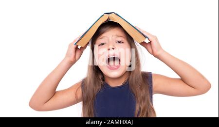 Petite fille avec un livre ouvert sur sa tête est en colère. Banque D'Images