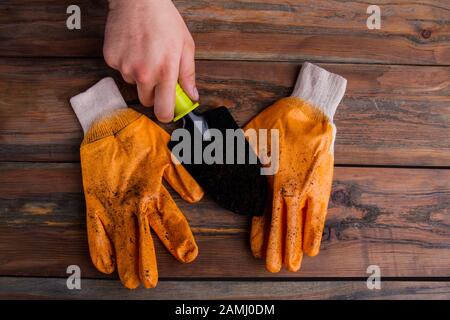 L'homme tient la pelle de jardin noire. Banque D'Images