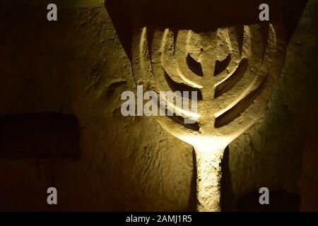 Ancienne grotte dessin d'une menorah dans Bet Elle'arim National Park Cave des Coffins à Kiryat Tiv'on Israel en juin 2019 Banque D'Images