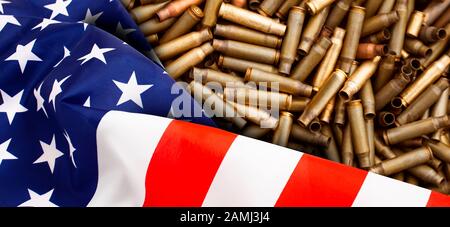 Drapeau américain isolé sur fond de cartouches de fusil de chasse. Vue de dessus, espace de copie pour le texte. Banque D'Images