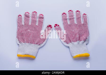 Paire de gants de protection en coton de travail avec points en caoutchouc rouge. Banque D'Images